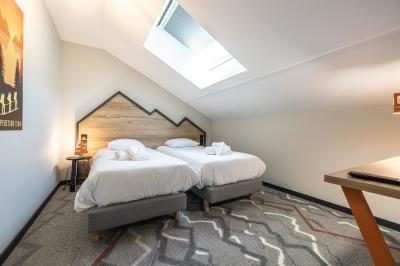 Un groupe de musiciens joue sur scène devant un écran affichant le logo et le slogan ’Base Camp Lodge’.