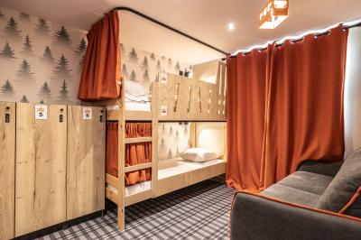 Un groupe de musiciens joue sur scène devant un écran affichant le logo et le slogan ’Base Camp Lodge’.