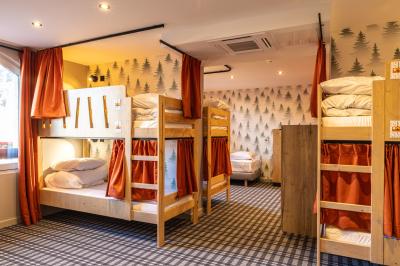 Un groupe de musiciens joue sur scène devant un écran affichant le logo et le slogan ’Base Camp Lodge’.