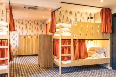 Un groupe de musiciens joue sur scène devant un écran affichant le logo et le slogan ’Base Camp Lodge’.