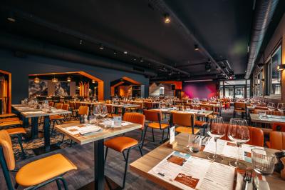 Un groupe de musiciens joue sur scène devant un écran affichant le logo et le slogan ’Base Camp Lodge’.