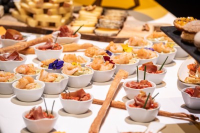 Un groupe de musiciens joue sur scène devant un écran affichant le logo et le slogan ’Base Camp Lodge’.