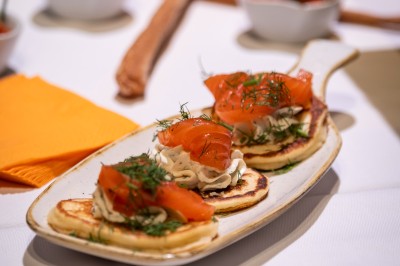 Un groupe de musiciens joue sur scène devant un écran affichant le logo et le slogan ’Base Camp Lodge’.