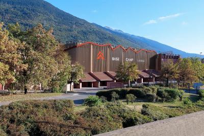 Un groupe de musiciens joue sur scène devant un écran affichant le logo et le slogan ’Base Camp Lodge’.