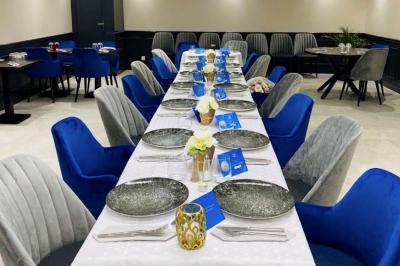 Plateau de fruits frais avec mangue, pomme, raisin et menthe, présenté sur une table lors d'un événement convivial.