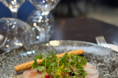 Assiette de pâtes garnie d'herbes fraîches servie avec des frites dans un restaurant à l'ambiance tamisée.