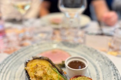 Assiette de pâtes garnie d'herbes fraîches servie avec des frites dans un restaurant à l'ambiance tamisée.