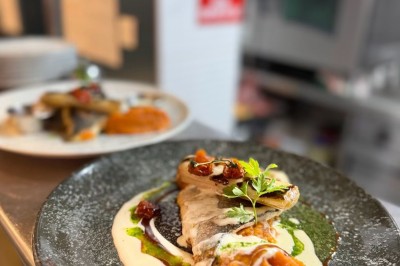 Assiette de pâtes garnie d'herbes fraîches servie avec des frites dans un restaurant à l'ambiance tamisée.