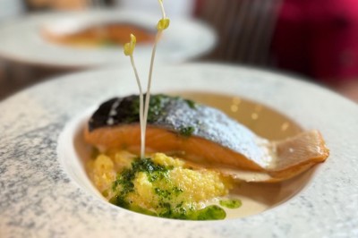 Assiette de pâtes garnie d'herbes fraîches servie avec des frites dans un restaurant à l'ambiance tamisée.
