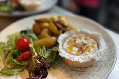 Assiette de pâtes garnie d'herbes fraîches servie avec des frites dans un restaurant à l'ambiance tamisée.