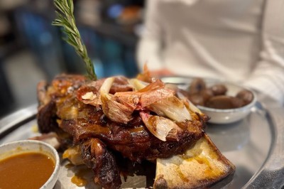 Assiette de pâtes garnie d'herbes fraîches servie avec des frites dans un restaurant à l'ambiance tamisée.
