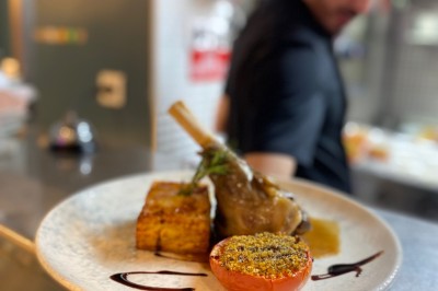 Assiette de pâtes garnie d'herbes fraîches servie avec des frites dans un restaurant à l'ambiance tamisée.