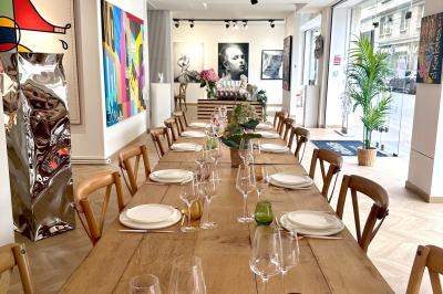 Salle de restaurant avec des tables dressées, décorée de grandes photographies en noir et blanc sur les murs.