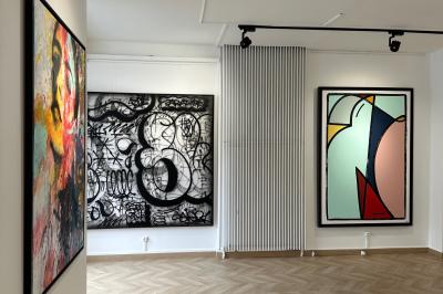 Salle de restaurant avec des tables dressées, décorée de grandes photographies en noir et blanc sur les murs.