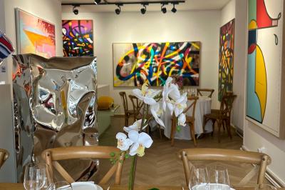 Salle de restaurant avec des tables dressées, décorée de grandes photographies en noir et blanc sur les murs.
