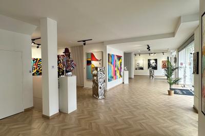Salle de restaurant avec des tables dressées, décorée de grandes photographies en noir et blanc sur les murs.