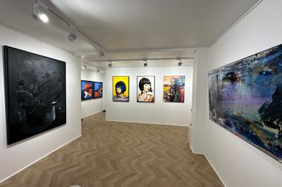 Salle de restaurant avec des tables dressées, décorée de grandes photographies en noir et blanc sur les murs.