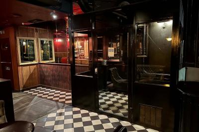 Miniature Location salle Lyon (Rhône) - L'Idole des Jeunes #6 Intérieur d'un bar avec un lustre central, des murs ornés de cadres et un comptoir en bois sombre.