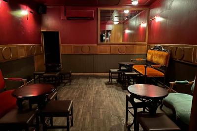 Miniature Location salle Lyon (Rhône) - L'Idole des Jeunes #8 Intérieur d'un bar avec un lustre central, des murs ornés de cadres et un comptoir en bois sombre.