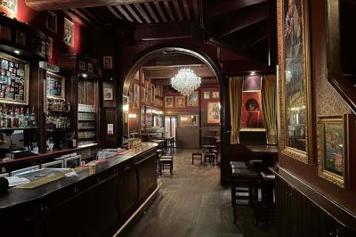 Miniature Location salle Lyon (Rhône) - L'Idole des Jeunes #10 Intérieur d'un bar avec un lustre central, des murs ornés de cadres et un comptoir en bois sombre.