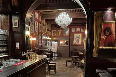 Miniature Location salle Lyon (Rhône) - L'Idole des Jeunes #14 Intérieur d'un bar avec un lustre central, des murs ornés de cadres et un comptoir en bois sombre.