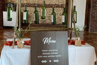Salle de réception en briques avec éclairage chaleureux, grande table décorée de fleurs et vaisselle élégante.