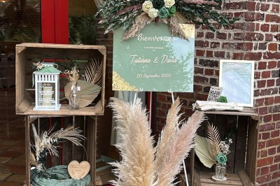 Salle de réception en briques avec éclairage chaleureux, grande table décorée de fleurs et vaisselle élégante.