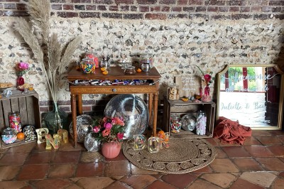 Salle de réception en briques avec éclairage chaleureux, grande table décorée de fleurs et vaisselle élégante.