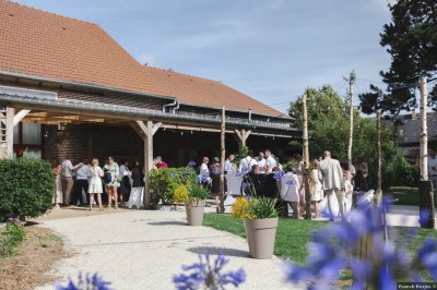 Salle de réception en briques avec éclairage chaleureux, grande table décorée de fleurs et vaisselle élégante.