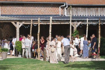 Salle de réception en briques avec éclairage chaleureux, grande table décorée de fleurs et vaisselle élégante.