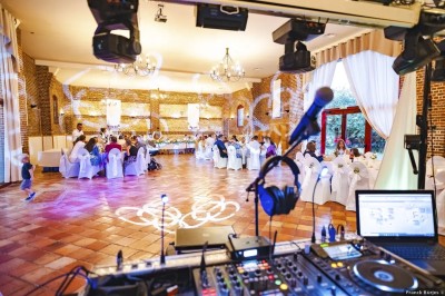 Salle de réception en briques avec éclairage chaleureux, grande table décorée de fleurs et vaisselle élégante.
