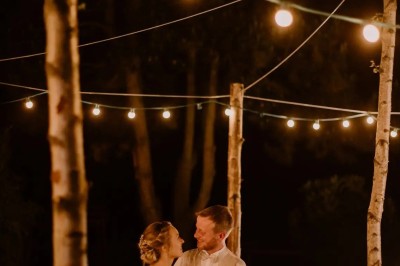 Salle de réception en briques avec éclairage chaleureux, grande table décorée de fleurs et vaisselle élégante.