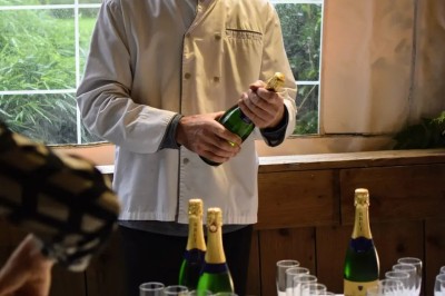 Salle de réception en briques avec éclairage chaleureux, grande table décorée de fleurs et vaisselle élégante.
