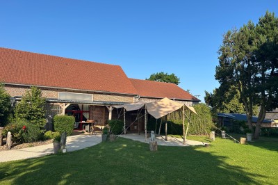 Salle de réception en briques avec éclairage chaleureux, grande table décorée de fleurs et vaisselle élégante.