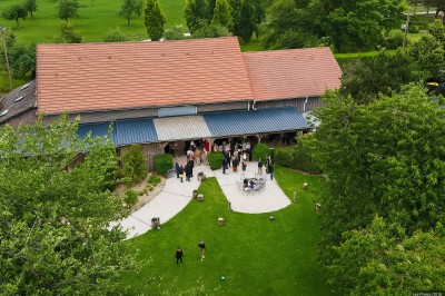 Salle de réception en briques avec éclairage chaleureux, grande table décorée de fleurs et vaisselle élégante.