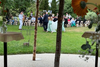 Salle de réception en briques avec éclairage chaleureux, grande table décorée de fleurs et vaisselle élégante.