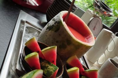 Salade de quinoa dans un grand bol entourée de petits plats contenant divers légumes sur une table en bois.