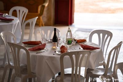 Château entouré d'arbres et de champs verdoyants sous un ciel partiellement nuageux.