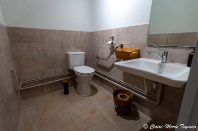 Château entouré d'arbres et de champs verdoyants sous un ciel partiellement nuageux.