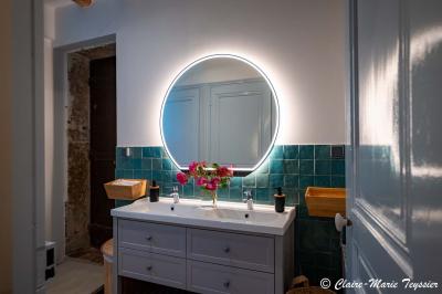 Château entouré d'arbres et de champs verdoyants sous un ciel partiellement nuageux.