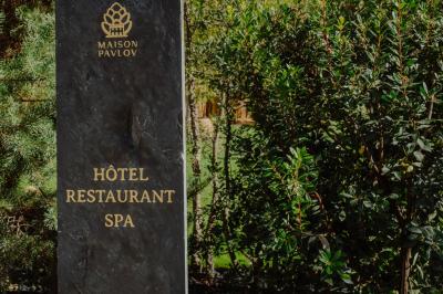 Fauteuil beige placé près d'un mur vert, avec un tableau encadré et des rideaux beiges en arrière-plan.