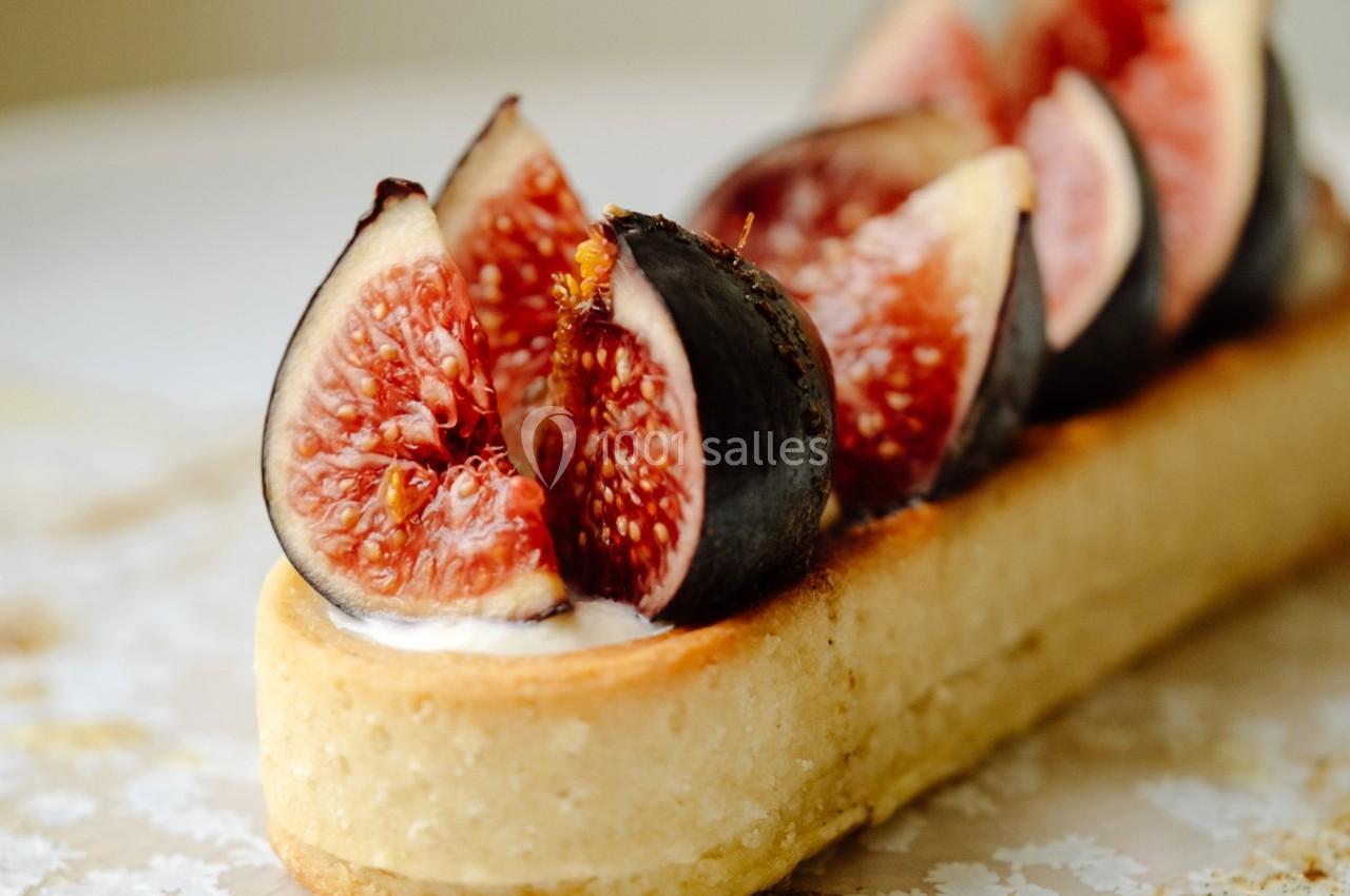 Tartelette garnie de figues fraîches coupées en quartiers sur une base de pâte dorée.