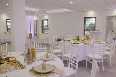 Des personnes assises assistent à une présentation dans une salle éclairée par des lumières violettes.