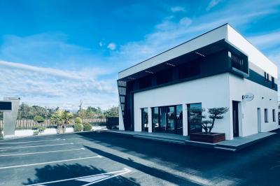 Des personnes assises assistent à une présentation dans une salle éclairée par des lumières violettes.