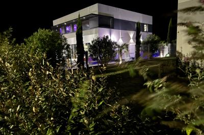 Des personnes assises assistent à une présentation dans une salle éclairée par des lumières violettes.