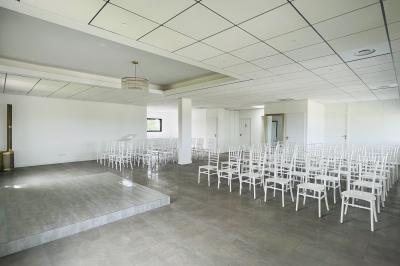 Des personnes assises assistent à une présentation dans une salle éclairée par des lumières violettes.