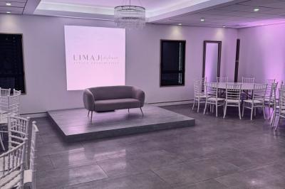 Des personnes assises assistent à une présentation dans une salle éclairée par des lumières violettes.