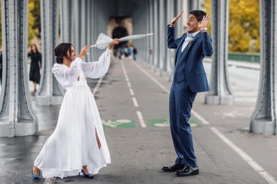 Un couple en tenue de mariage pose dans une forêt verdoyante, éclairée par une lumière douce.