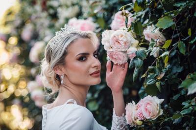 Un couple en tenue de mariage pose dans une forêt verdoyante, éclairée par une lumière douce.