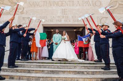 Un couple en tenue de mariage pose dans une forêt verdoyante, éclairée par une lumière douce.